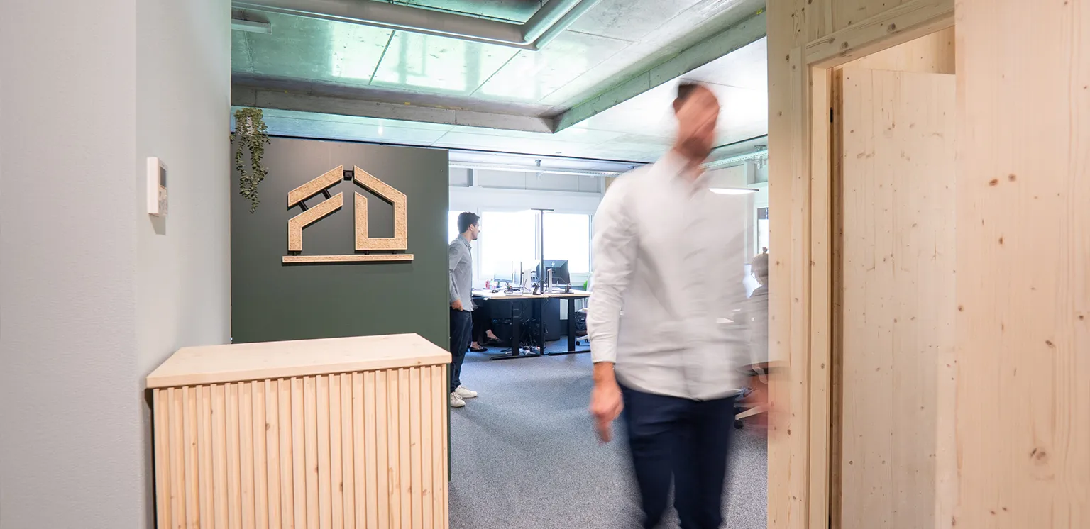 jobs-deflorin-headerbild3 Offener Bürobereich der Deflorin AG mit Holzelementen, modernen Arbeitsplätzen und Mitarbeitenden bei der Arbeit.